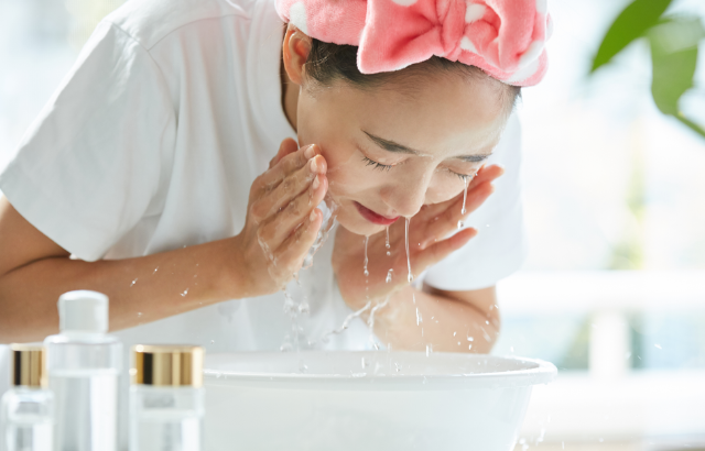 woman using skincare products to cleanse her face