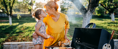 family outside alongside a grill