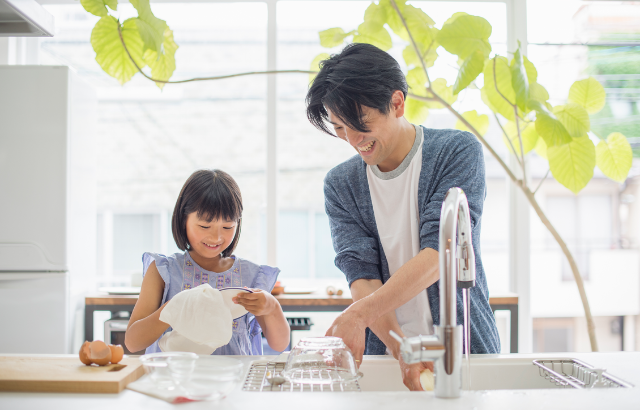 A man and child washing dishes together
