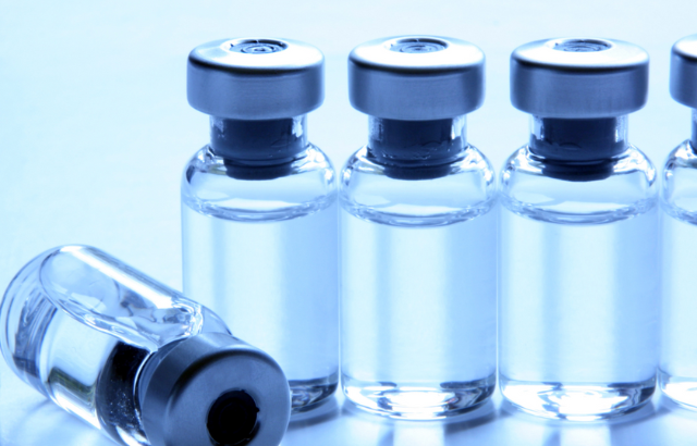 four medical vials filled with solution