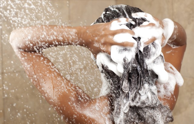 woman shampooing her hair with a rich thick shampoo lather