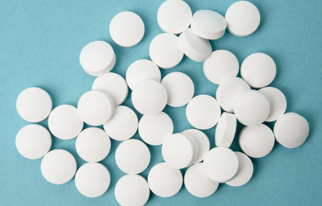 round pharamceutical pills onto of a blue background