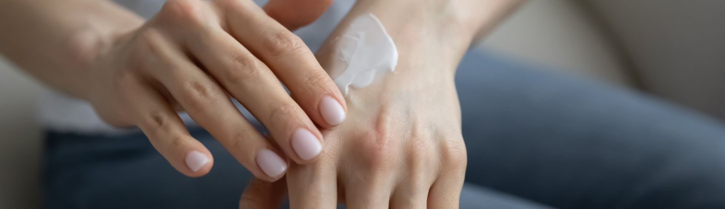 woman applying moisturizer to her hand