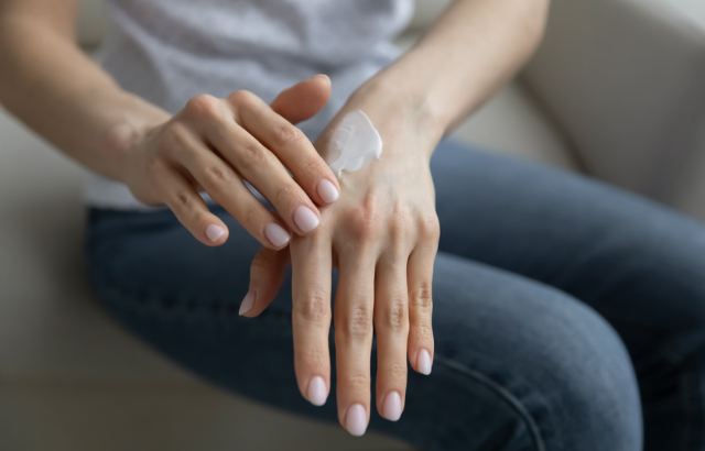 person rubbing lotion on her hands